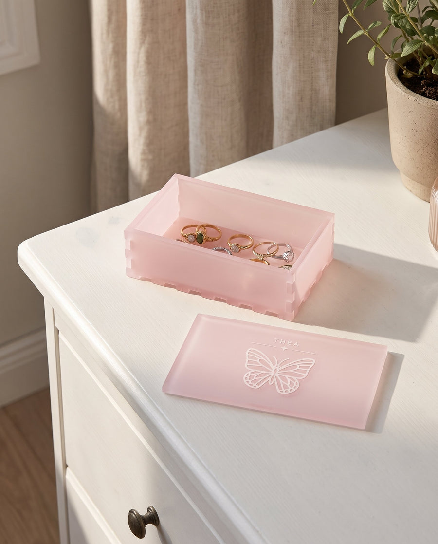 Sommerfugl: smykkeskrin i pink akryl med sommerfugl og navn – i brug